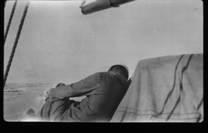 Image of Crewman on deck (sleeping?)